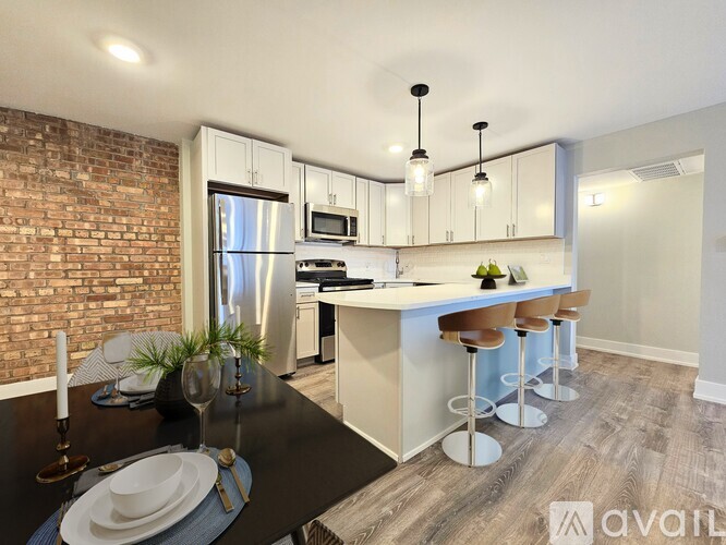 A modern kitchen with a black table and bar stools.