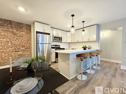 A modern kitchen with a black table and bar stools.