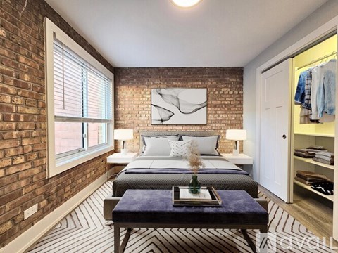 A bedroom with a brick wall and a bed with a blue blanket on it.