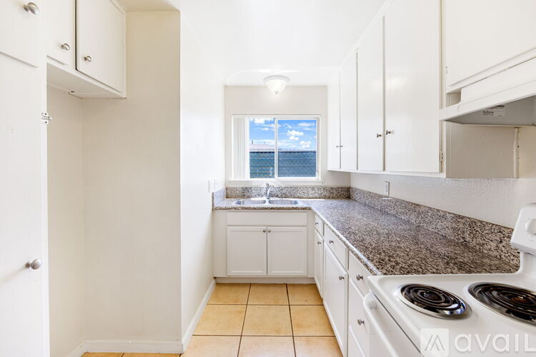 A kitchen with white cabinets and a granite countertop.