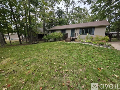 A house with a lawn and trees in the background.
