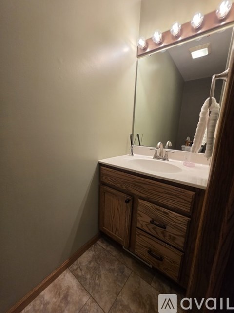 A bathroom with a sink, mirror, and lights.