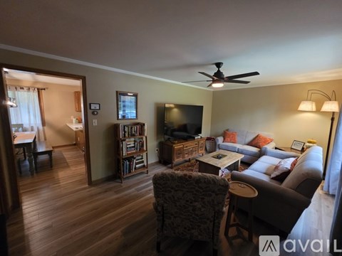 A living room with a couch, chair, and television.