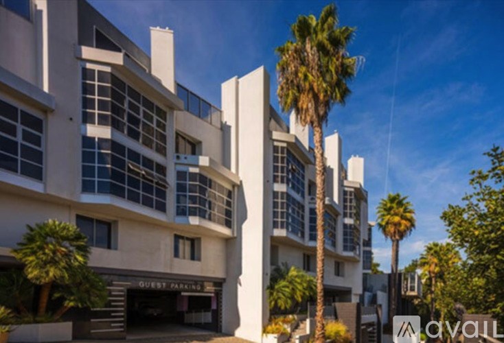 A tall building with a sign that says "guest parking" in front of it.