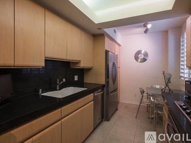 A kitchen with wooden cabinets and black countertops.