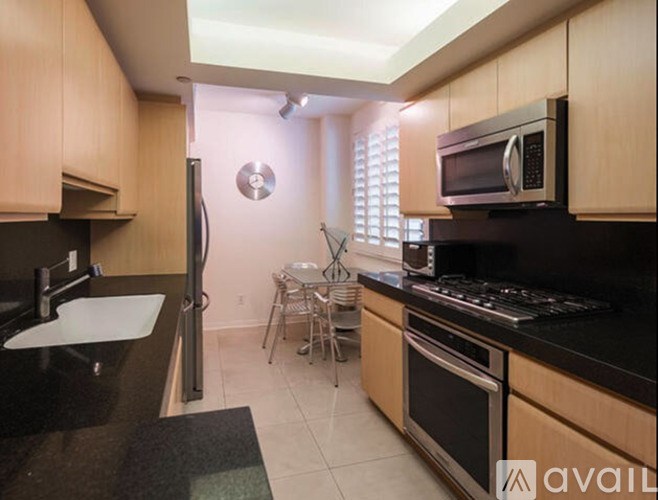 A kitchen with wooden cabinets and black countertops.