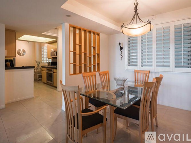 A dining room with a glass table and chairs.