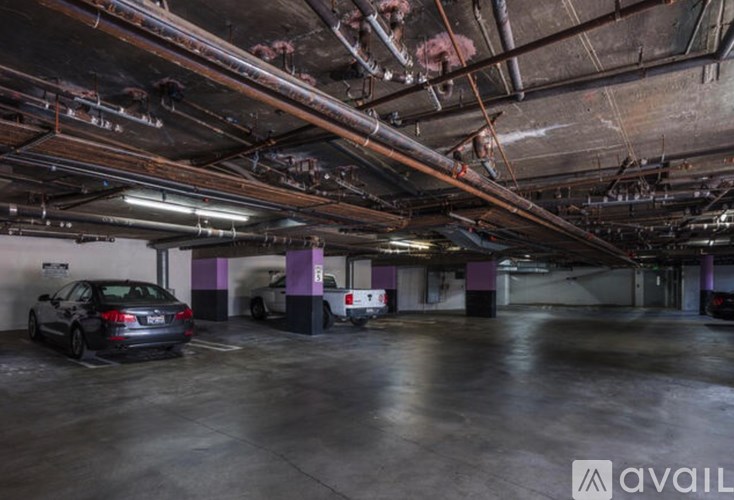 A parking garage with a car parked in the foreground.