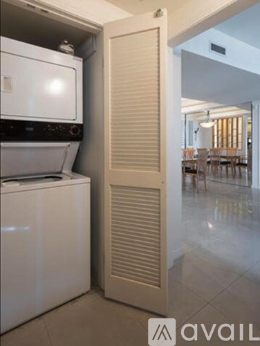 A white dishwasher is in a kitchen next to a white door.