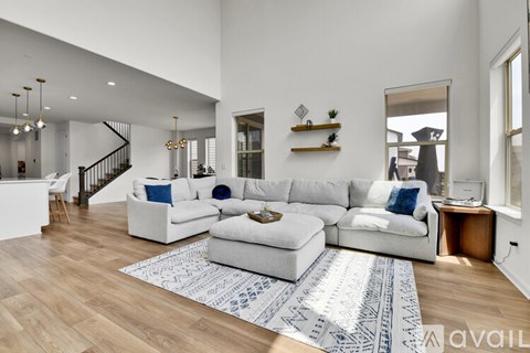 A living room with a white couch and a patterned rug.