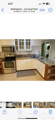 A kitchen with white cabinets and a green appliance.