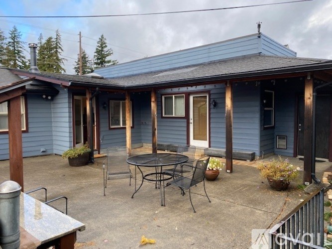 A blue house with a patio and a table.
