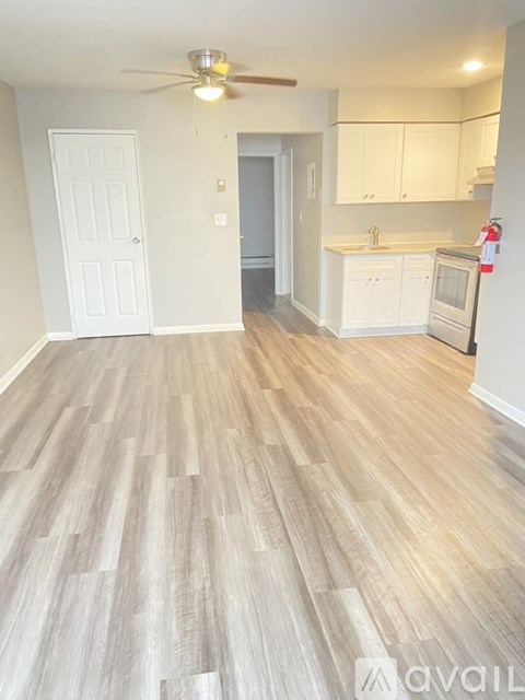 A kitchen with a white door and a ceiling fan.