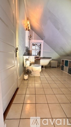 A bathroom with a toilet and a window.