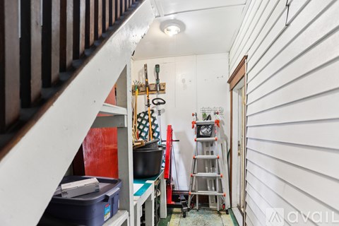 A small room with a ladder and a toolbox.
