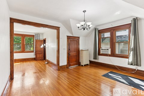 A room with wooden floors and a chandelier hanging from the ceiling.