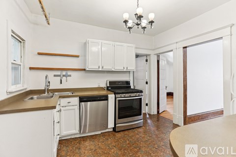 A kitchen with white cabinets and a brown countertop.