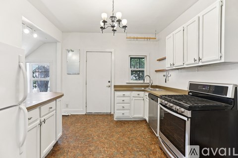 A kitchen with white cabinets and a black stove top oven.