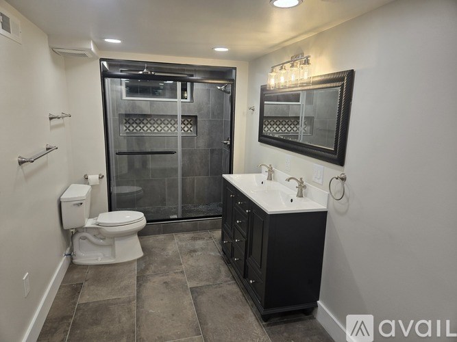 A bathroom with a toilet, sink, and walk-in shower.