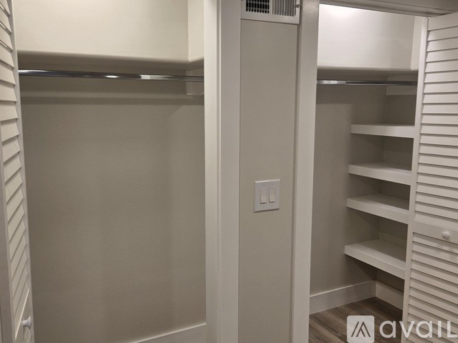 A white closet with shelves and a light switch.