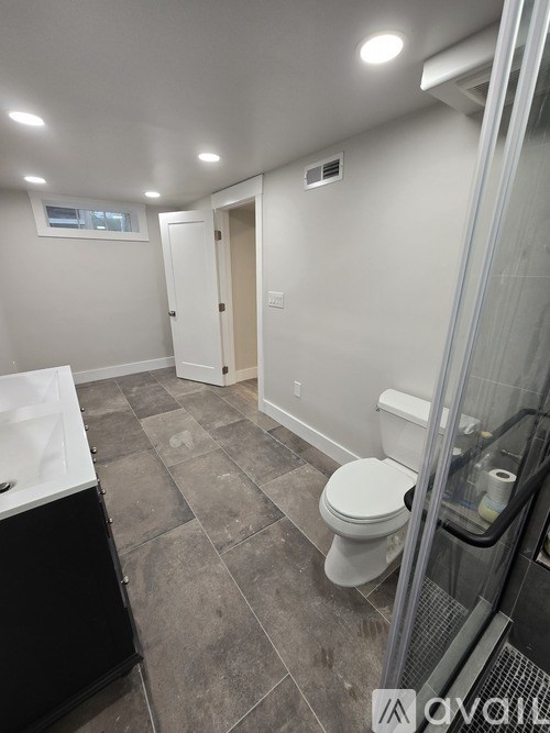 A bathroom with a toilet, sink, and shower.