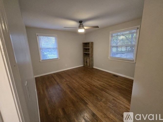 A room with wooden flooring and a ceiling fan.