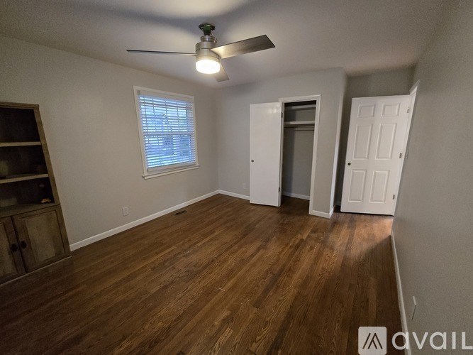 A room with wooden floors and a ceiling fan.