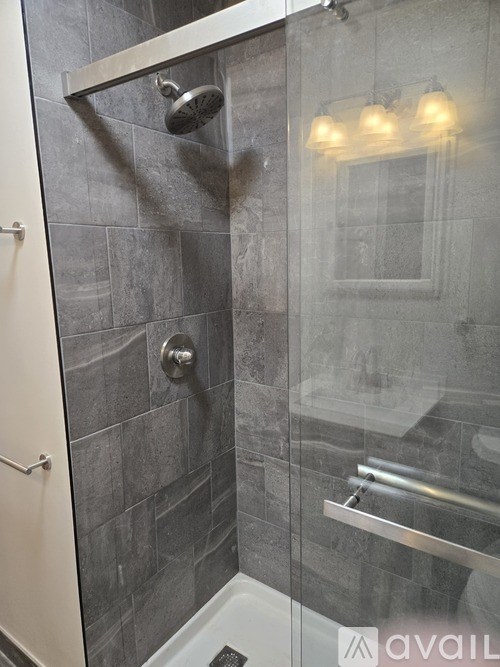 A shower area with a glass door and a glass wall.