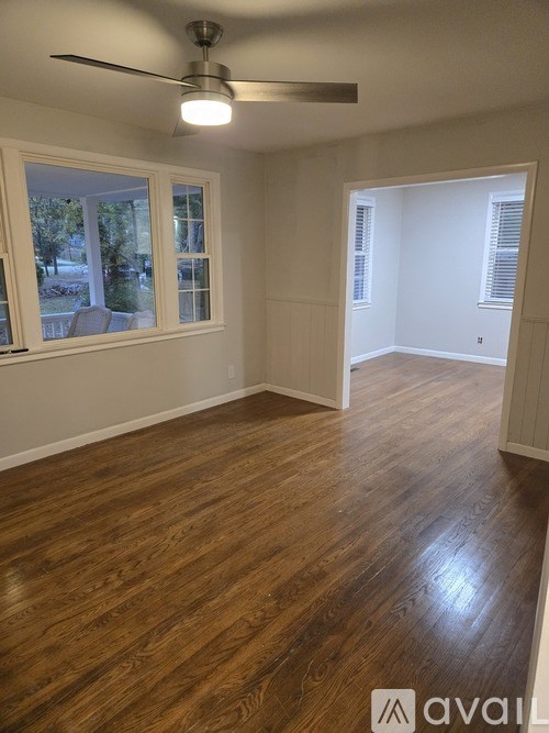 A room with wooden floors and a ceiling fan.