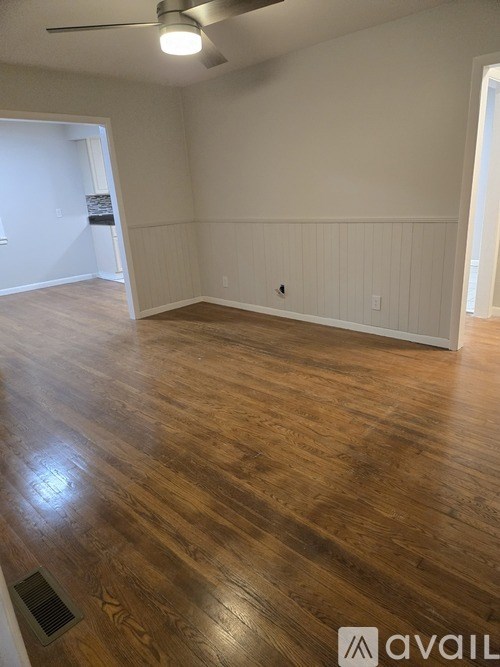 A room with wooden flooring and a ceiling fan.