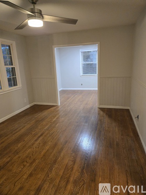 A room with wooden flooring and a ceiling fan.