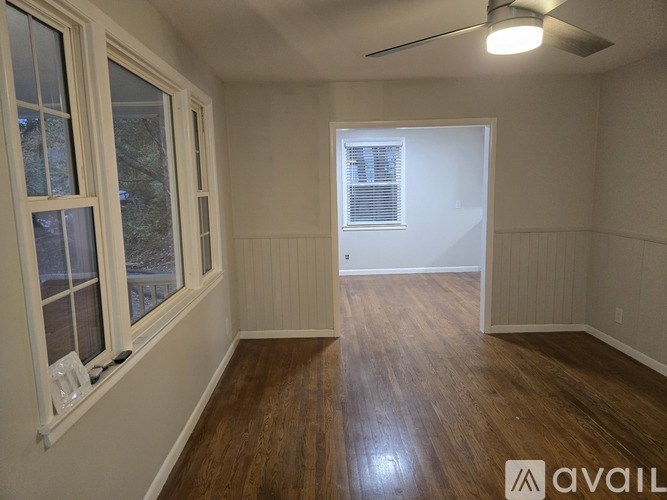 A room with wooden floors and a ceiling fan.