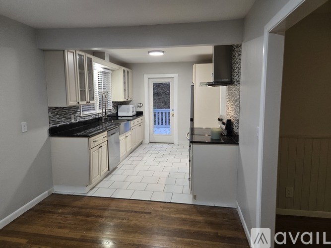 A kitchen with white cabinets and a black countertop.
