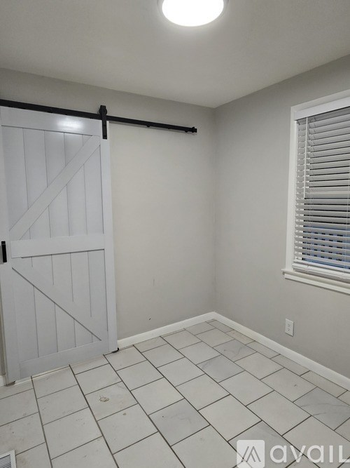 A room with a white door and a window with blinds.