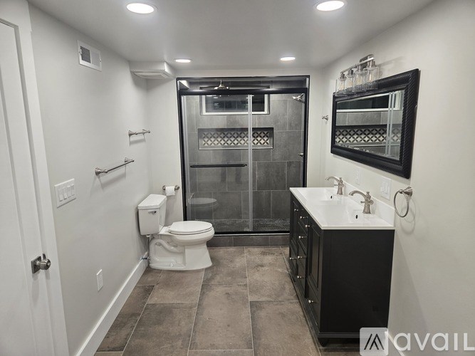 A bathroom with a toilet, sink, and walk-in shower.