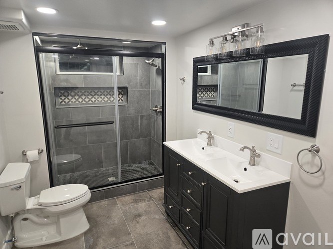 A bathroom with a toilet, sink, and walk-in shower.