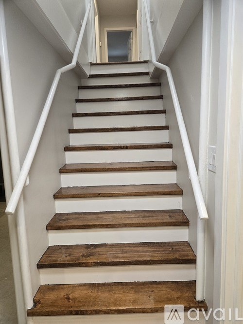 A staircase with wooden steps and white railings.