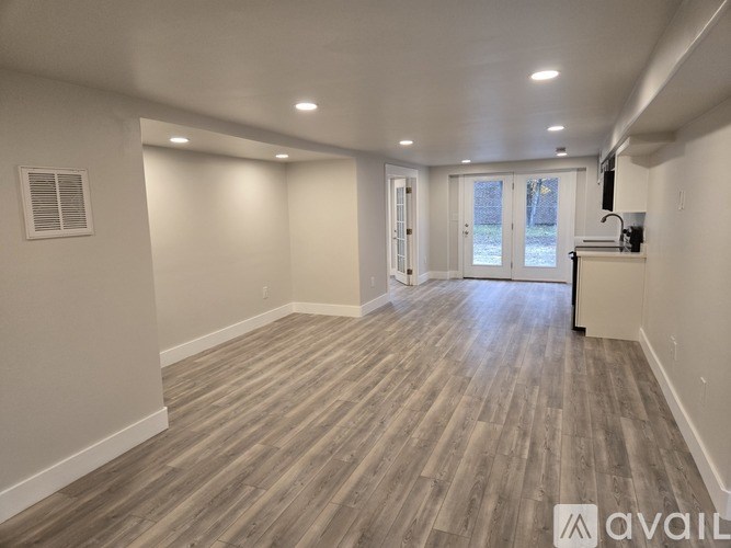 A room with wooden flooring and white walls.