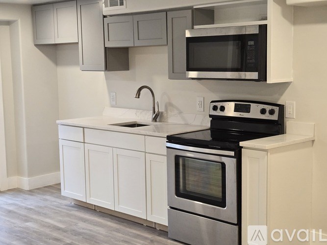 A modern kitchen with a stove top oven and microwave above it.