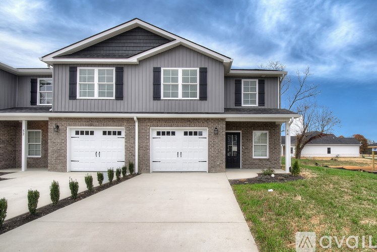 A two-story house with a garage is available for sale.