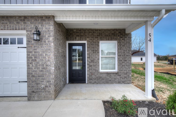 A house with a black front door and a white garage door.