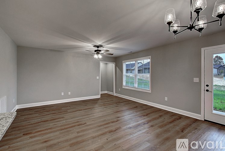 A living room with a ceiling fan and a chandelier.