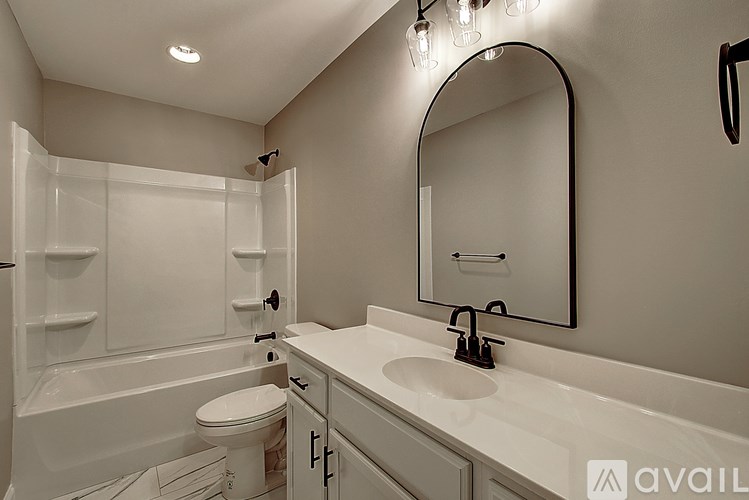 A bathroom with a white tub, sink, and toilet.