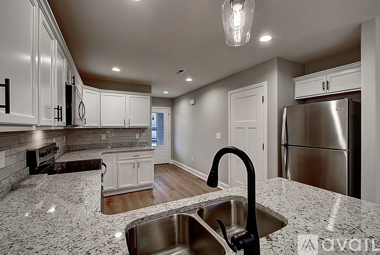 A modern kitchen with granite countertops and stainless steel appliances.
