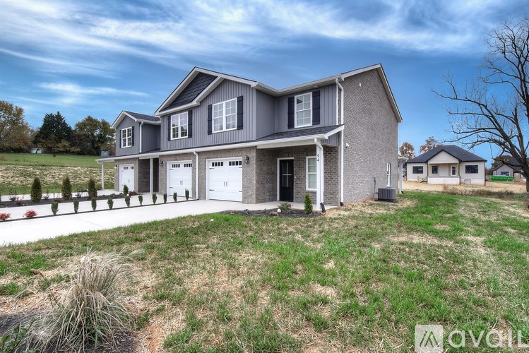 A modern house with a grey exterior and a large front yard.