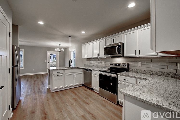 A kitchen with white cabinets and a granite countertop.