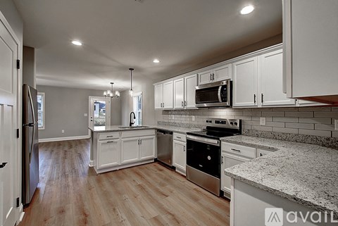 A kitchen with white cabinets and a granite countertop.