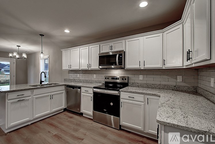 A kitchen with white cabinets and granite countertops.