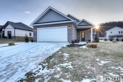 A house with a garage and a driveway covered in snow.