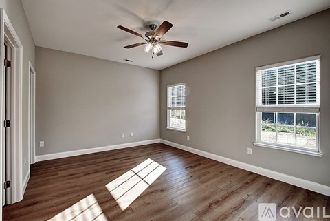 A room with a ceiling fan and a window with blinds.
